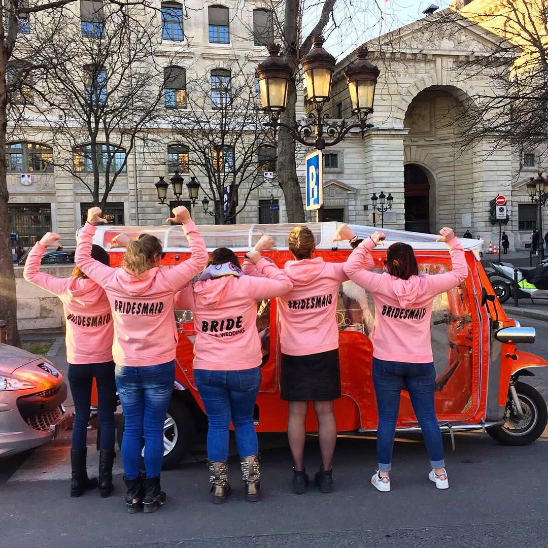 EVJF en tuktuk à Paris, équipe en tee-shirt rose devant un tuktuk