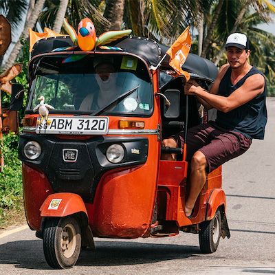 Tuktuk traditionnel orange au Sri Lanka, origine asiatique du tuktuk
