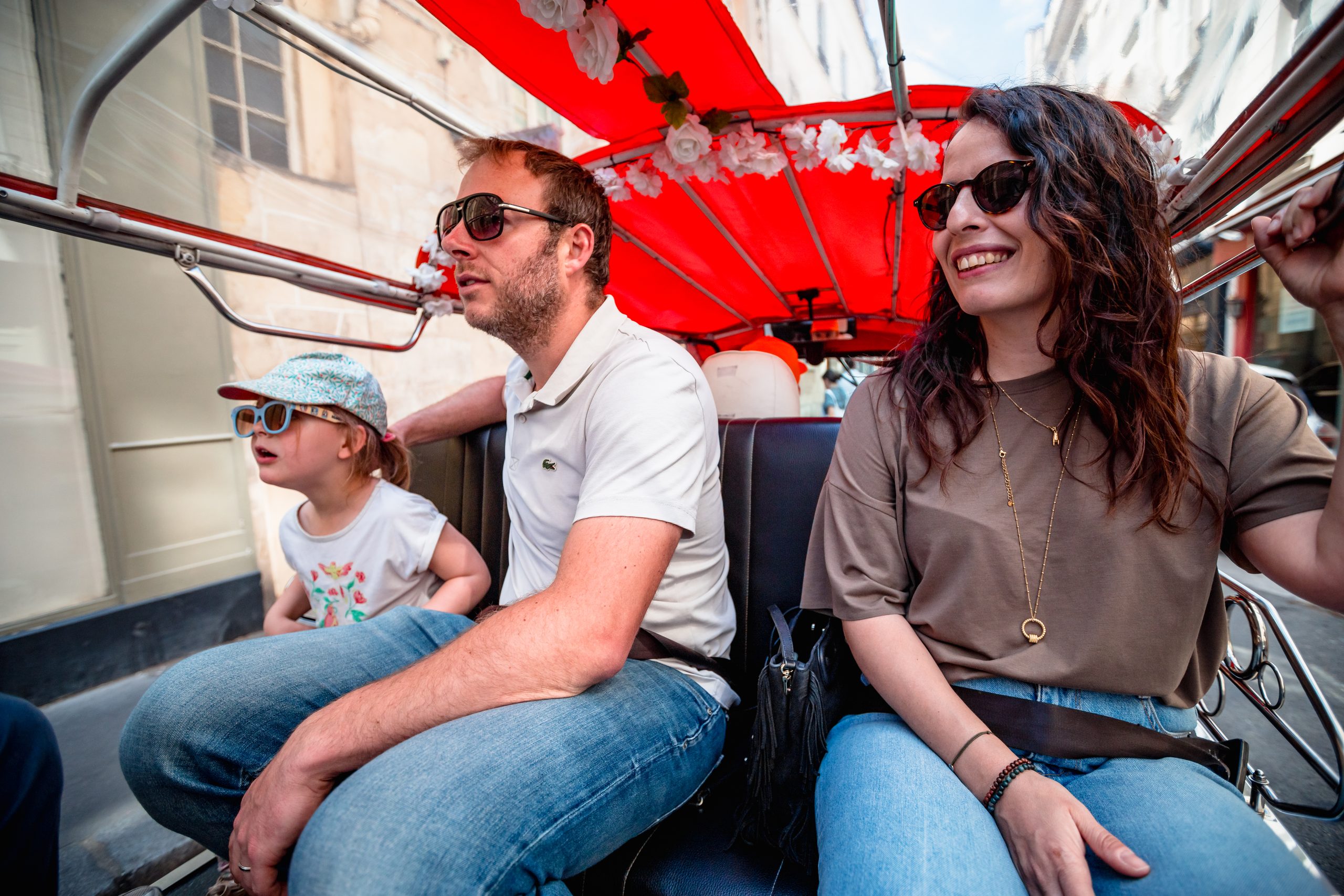 Famille en visite de Paris à bord d'un tuktuk électrique