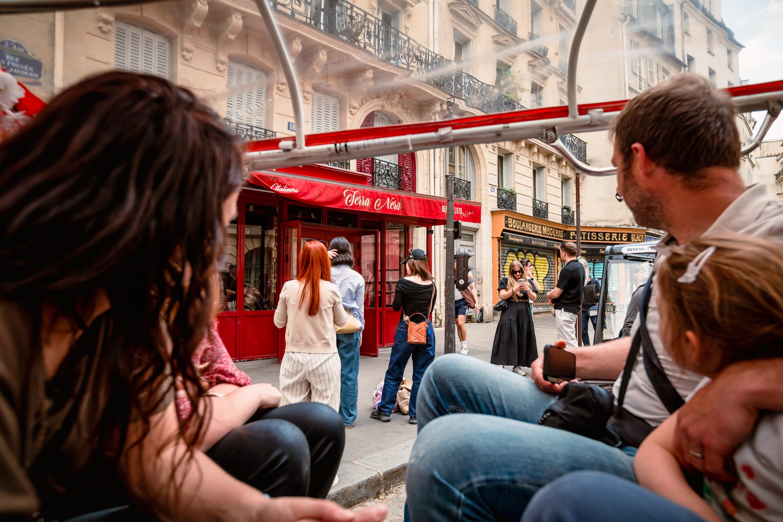 Passagers en visite de Paris à bord d'un tuktuk électrique