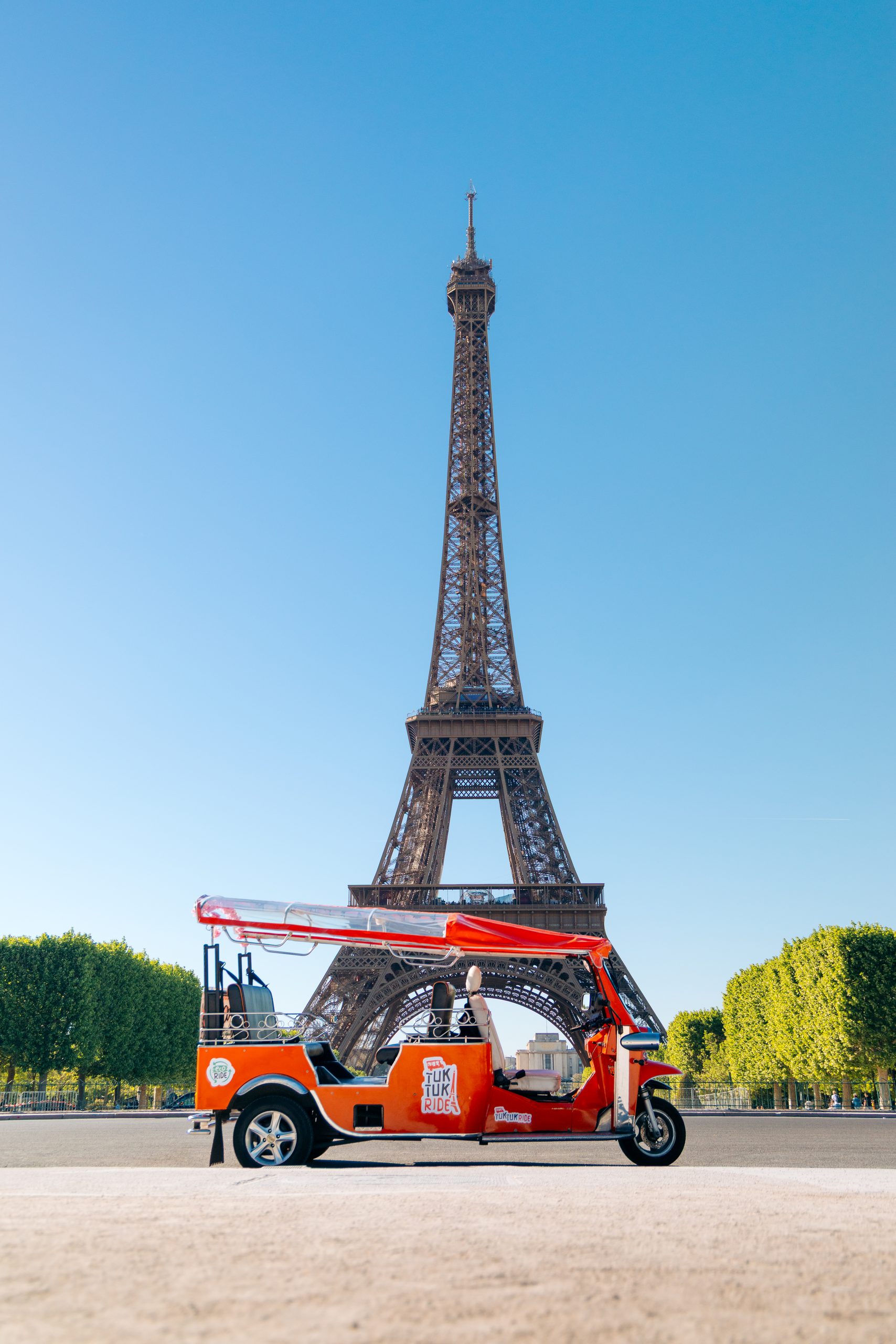 Tuktuk orange Tuktuk Ride devant la Tour Eiffel à Paris