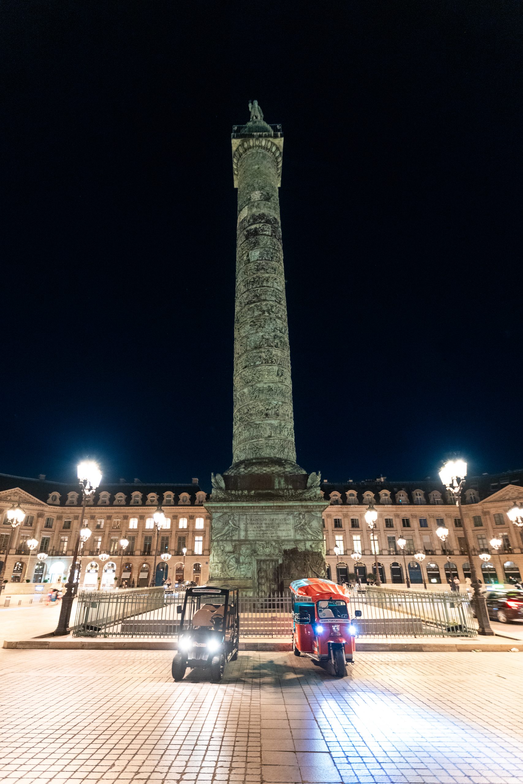 Tuktuk et golfette électrique devant la Colonne de Juillet Place de la Bastille de nuit