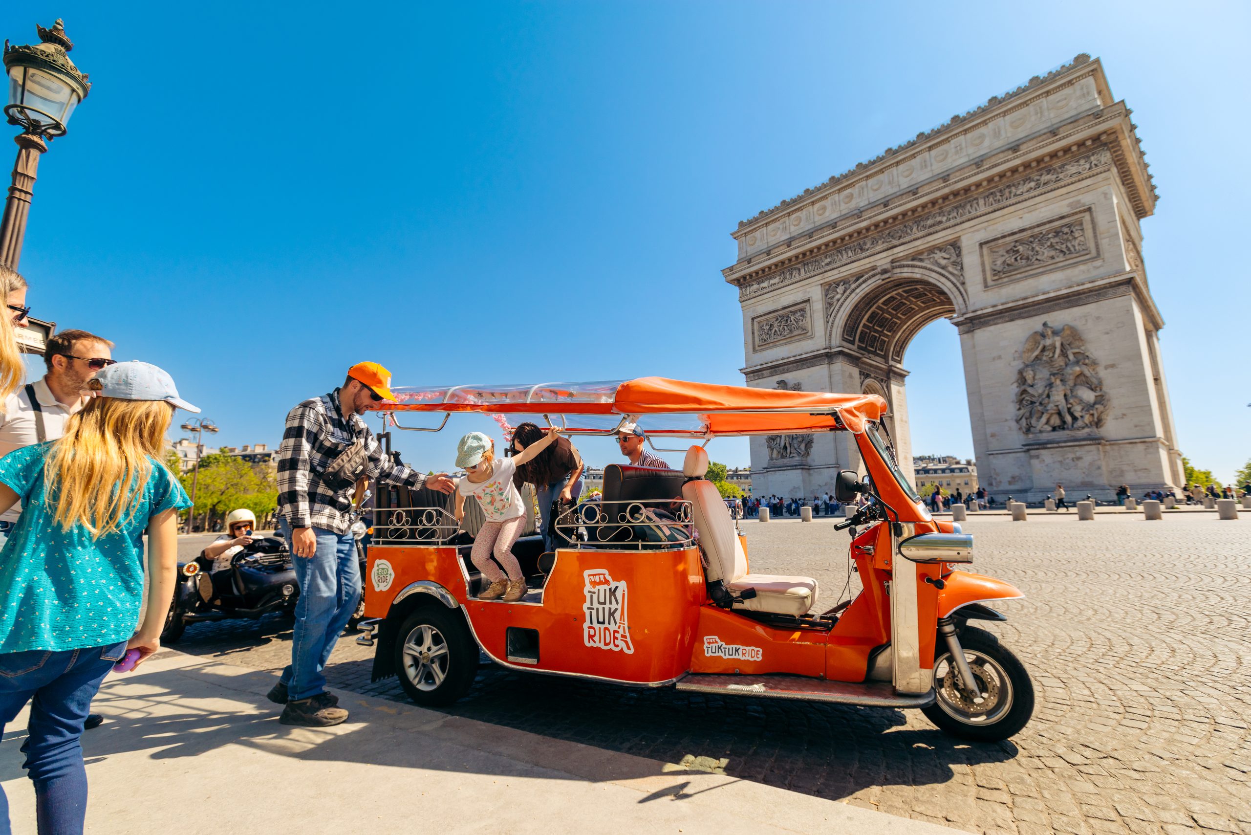 Passagers en tuktuk Tuktuk Ride devant l'Arc de Triomphe