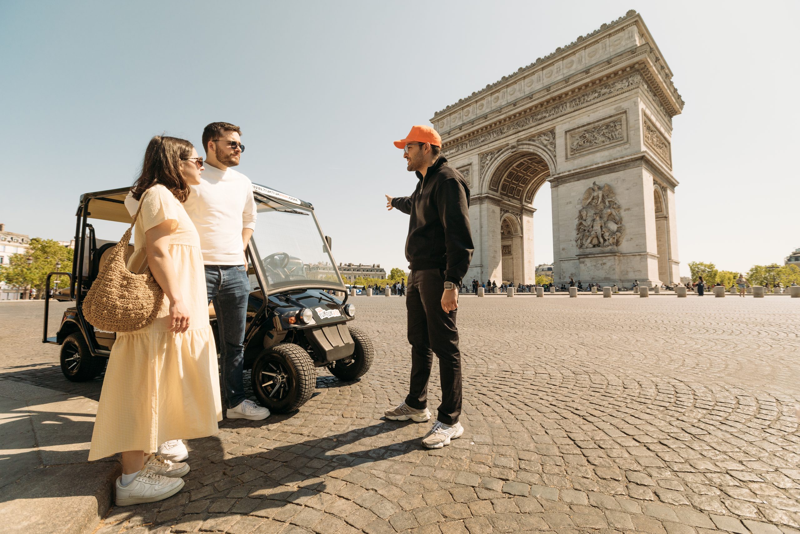 Couple et chauffeur Tuktuk Ride devant l'Arc de Triomphe à Paris